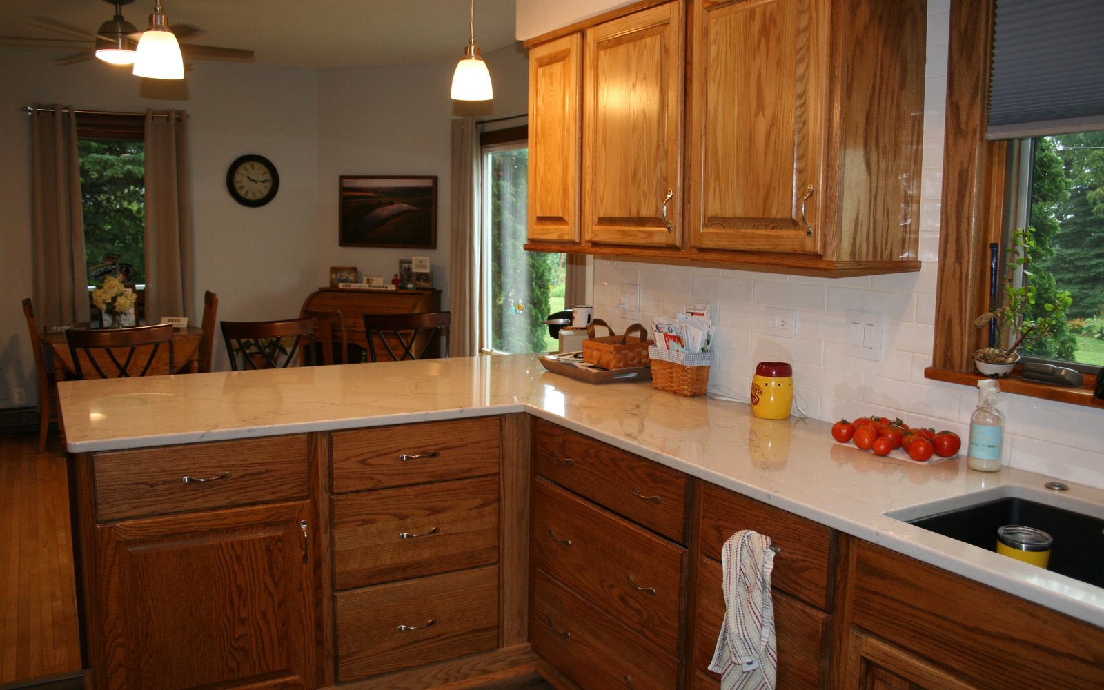 Warm oak kitchen cabinetry with a peninsula, deep drawers, and light counters