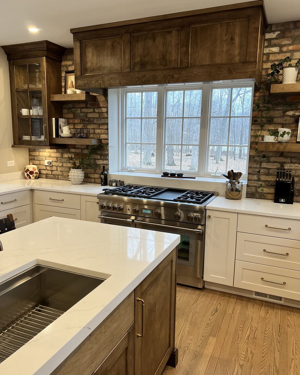 White kitchen cabinetry with stone backsplash, professional range, and wood display cabinets