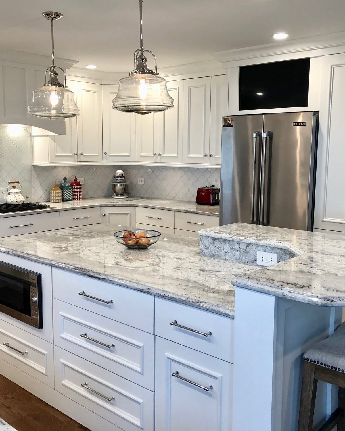 Painted kitchen cabinetry and island with granite counters and fitted drawer storage